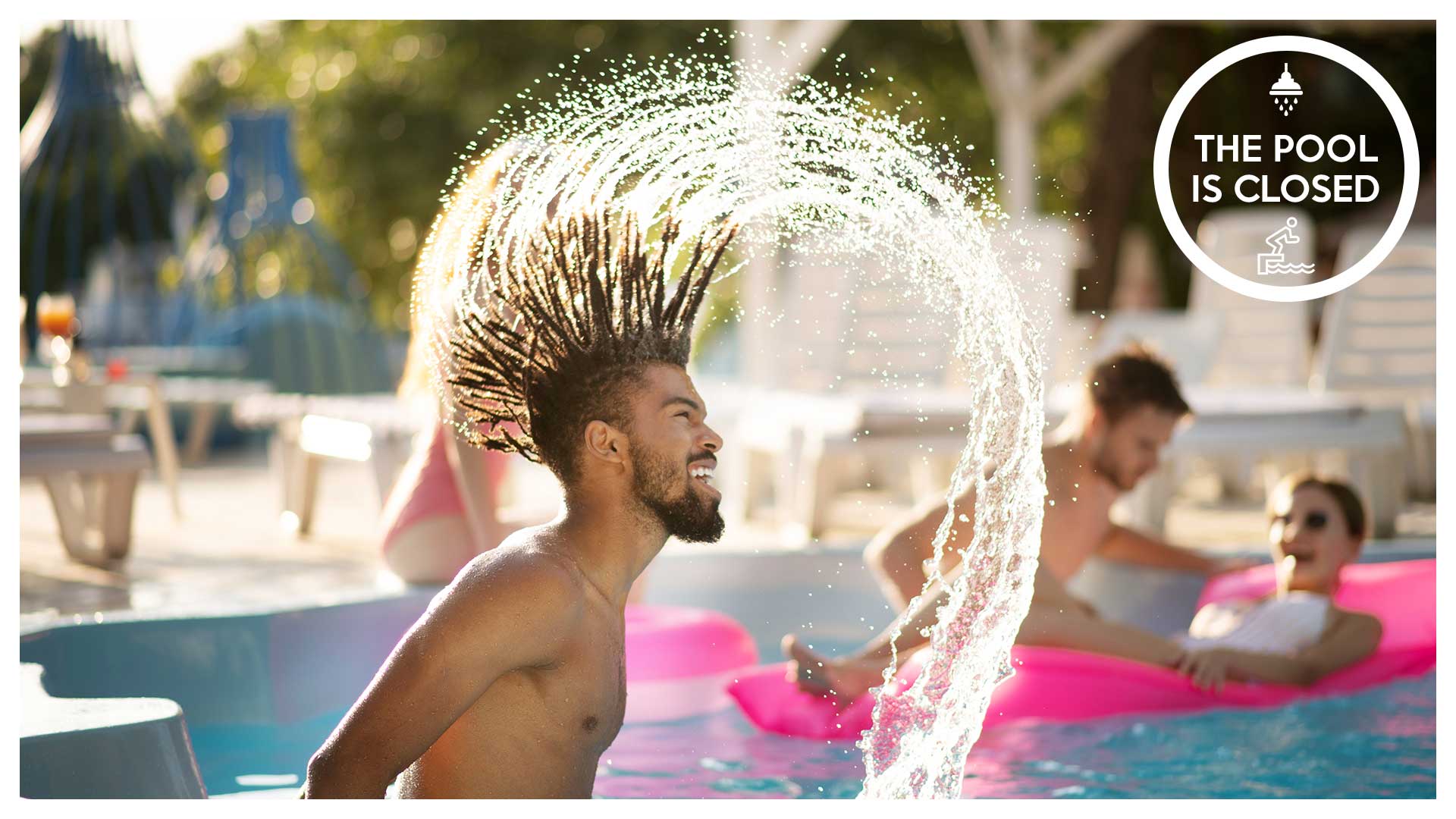 Bearded man with dreadlocks splashing water in pool